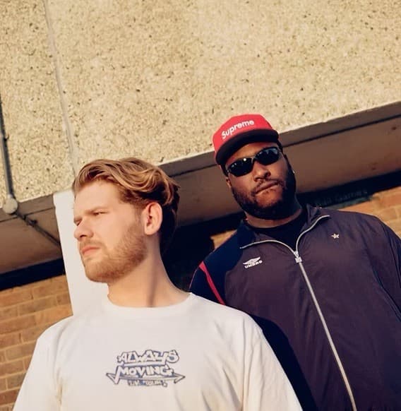 BexBlu and Paul Stephan standing against a brick wall